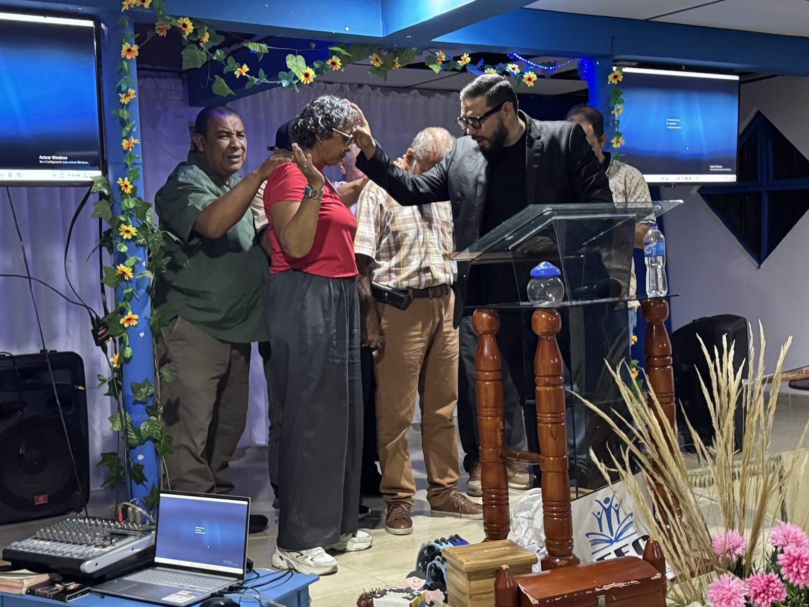 Hands laid on a woman in prayer at the altar of a local church